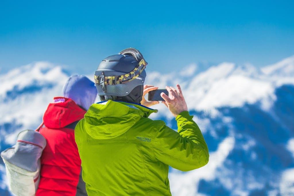 Two skiers capturing the breathtaking mountain views on a snowy winter day.
